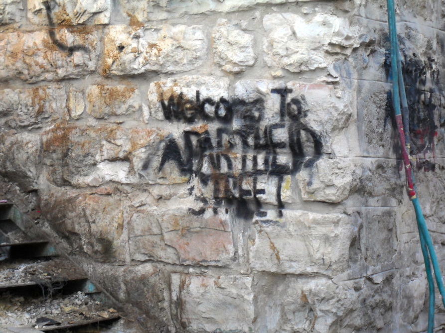 Graffiti near Shuhada welcoming visitors to "Apartheid Street."