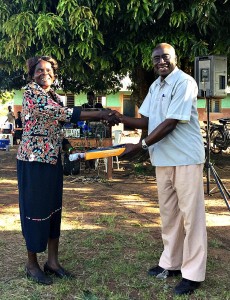 Head Teacher Madam Christine Accepting an Award from Local Council Chairman Mr Okumu Luriu